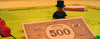 Monopoly game miniature icon person holding a five hundred dollar bill